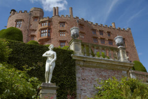 Looking up towards the south front above a statue on the terrace at Powis Castle and Garden, Powys.