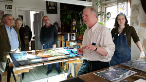 Board member John Clark (center) looks on while Tom Venturella, studio owner and Indre McCraw, painter, explain how a new commission is created.