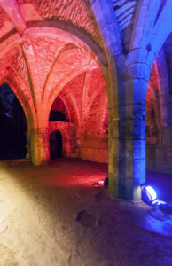 Fountains Abbey lit up with coloured lights at Christmas time, North Yorkshire. Built in 1132, Fountains Abbey is one of the best preserved Cistercian monasteries in England, and is now recognised as a World Heritage Site.