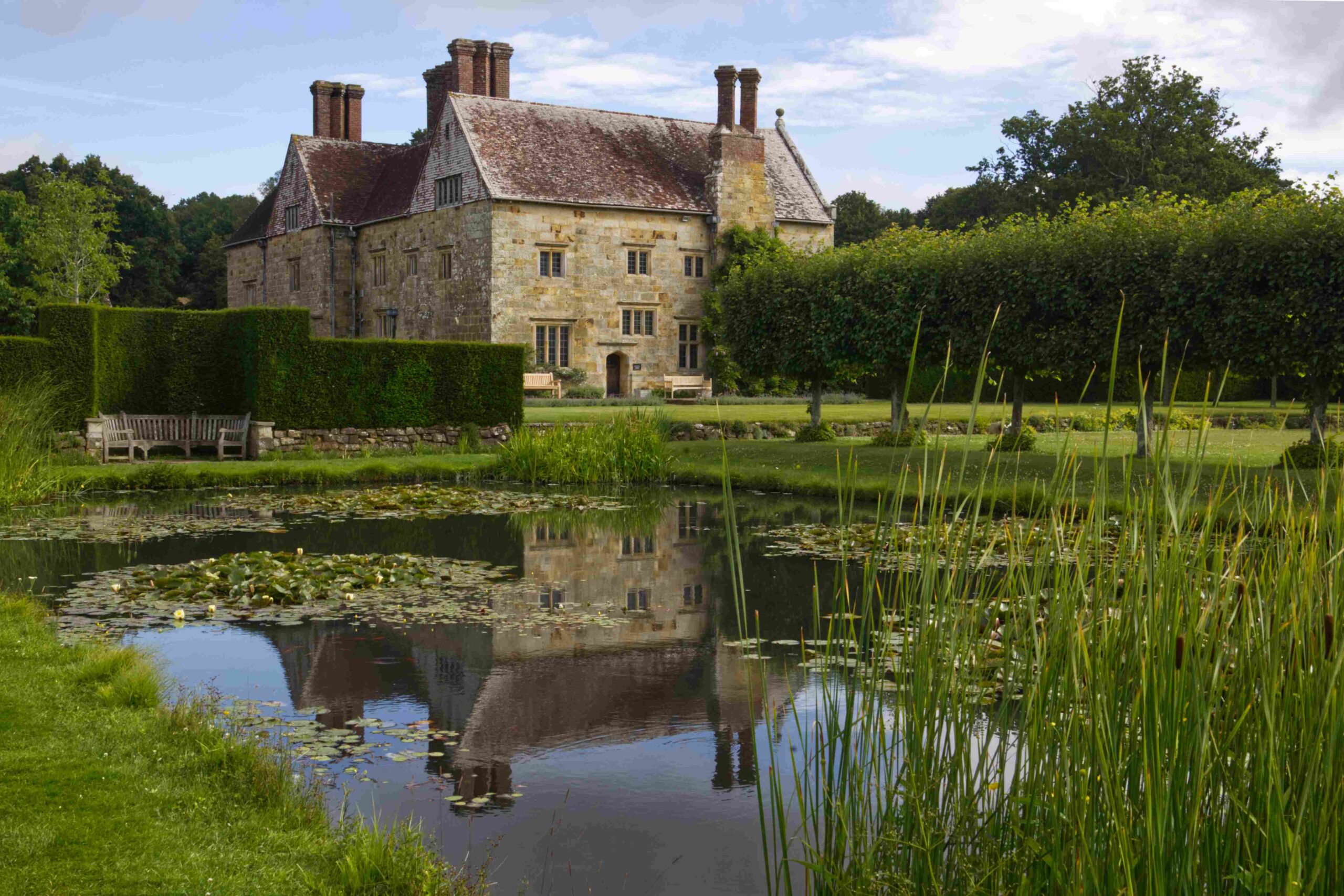 Bateman's. Stone manor house with garden and reflecting pond