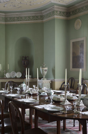 Dining room with set table and light green walls.