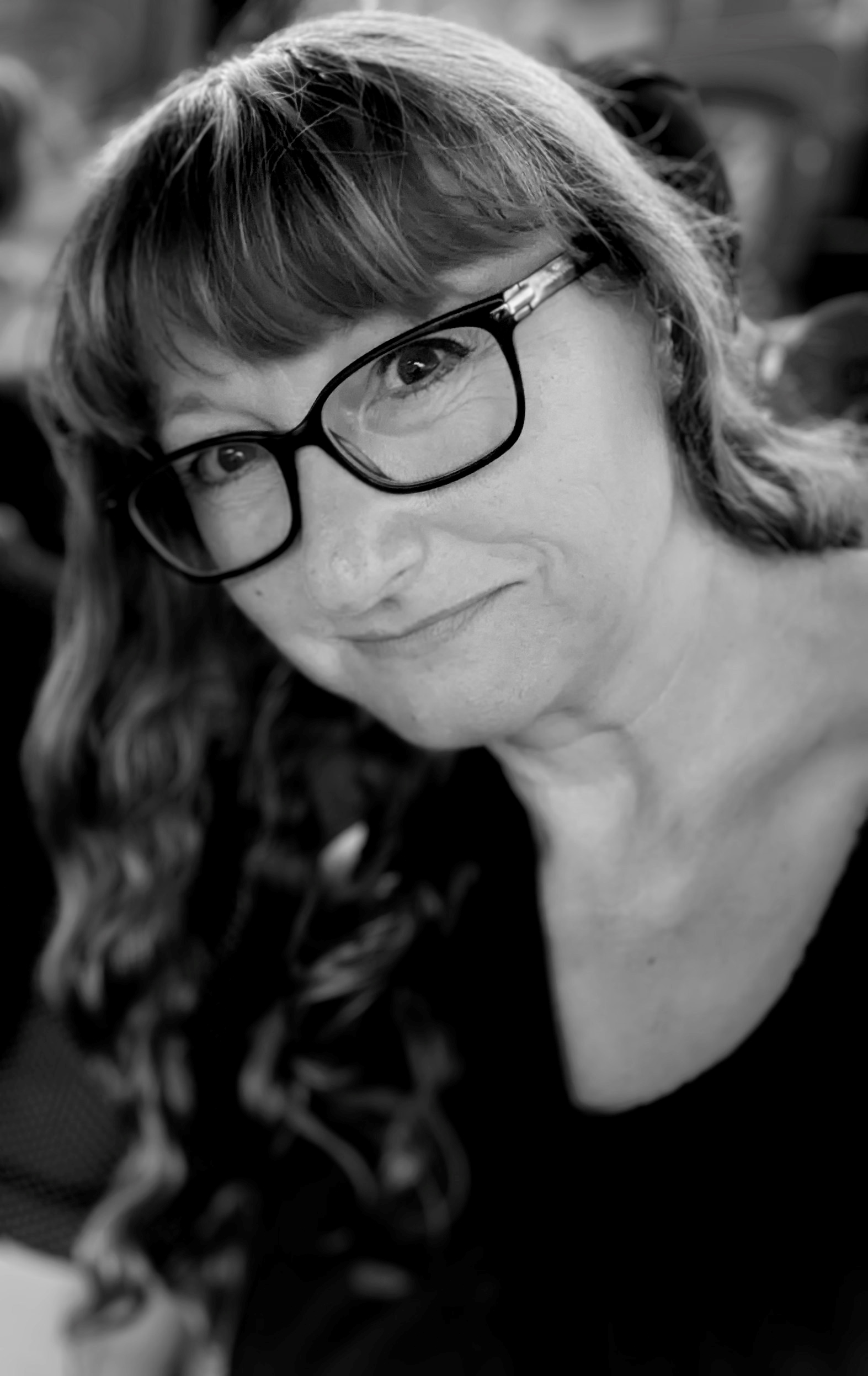 Headshot of Anna Sparham. White woman with light hair, wearing glasses. In a dark shirt. 